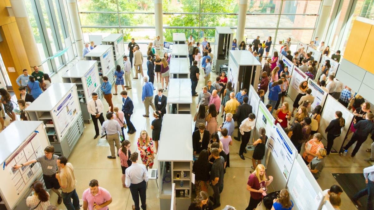 an overhead shot of a large crowd viewing research posters in the CSI cube